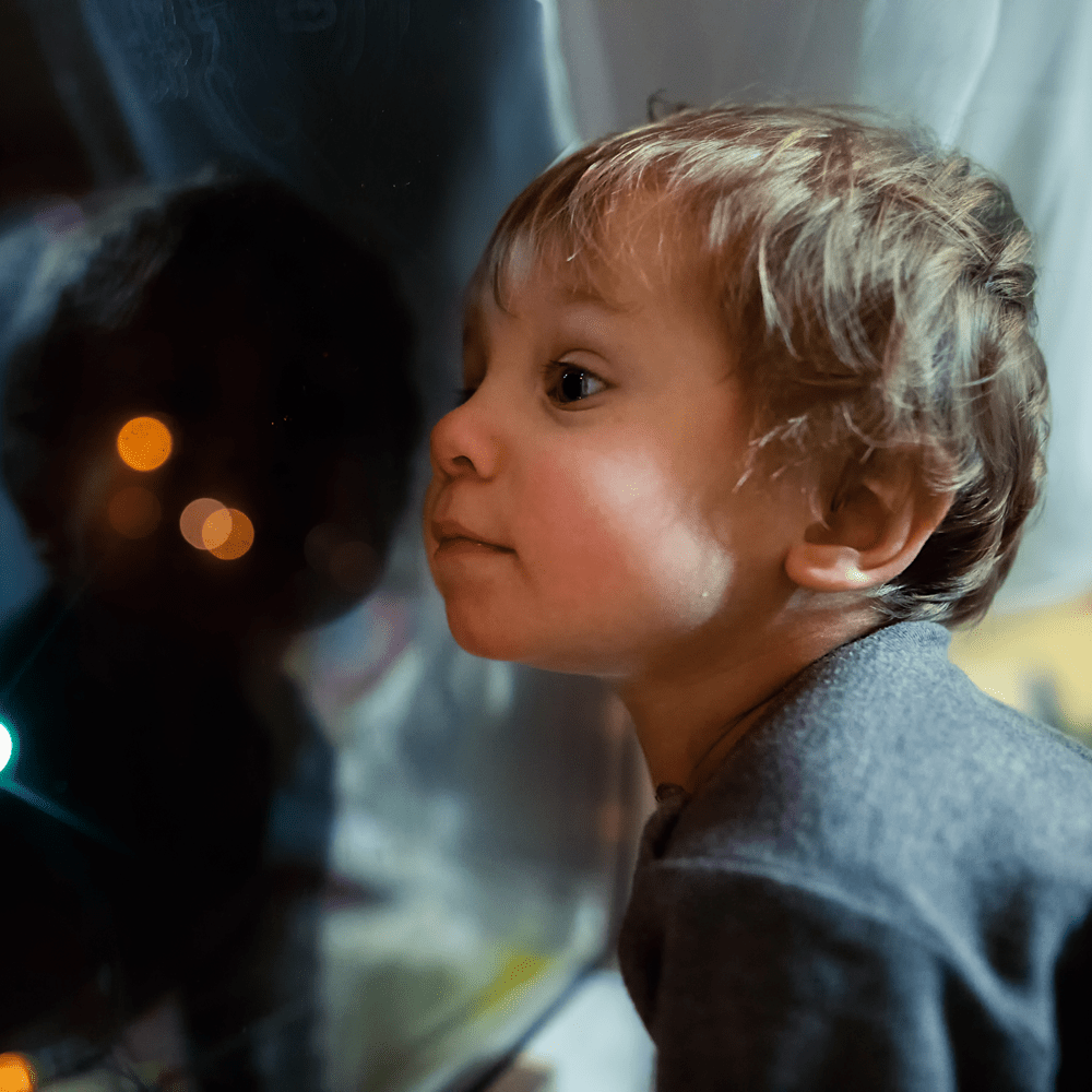 Petit-enfant impatient qui regarde par la fenêtre